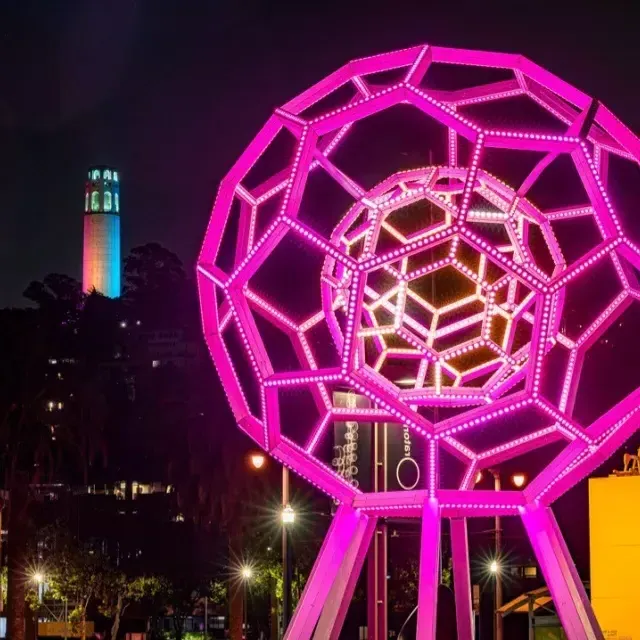 Buckyball shines outside the Exploratorium, with 屁股塔 in the background